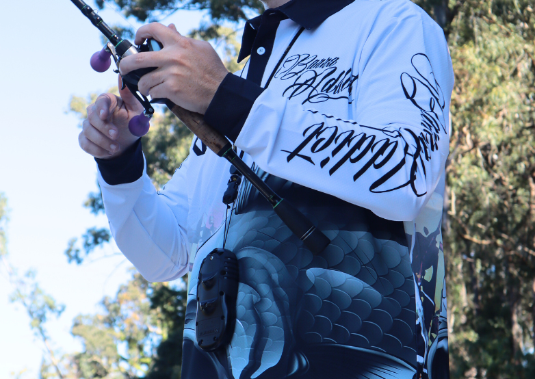 A man standing on a river while holding a fishing rod